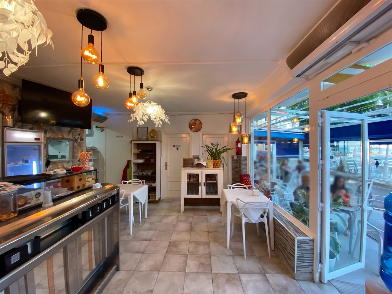 Comedor interior del restaurante Teide, con la barra, las lámparas cálidas y las mesas junto al ventanal.